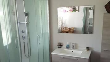 Regadera, secadora de cabello, toallas, papel de baño