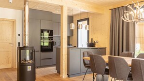 Moderni keittiö, jossa on harmaat kaapit, keskellä oleva keittiösaareke ja sisäänrakennettu liesi.