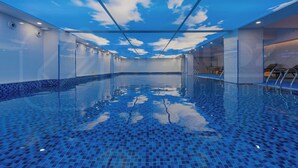 A spacious indoor swimming pool with a ceiling simulating a blue sky and clouds. - Holiday Inn One Thousand Island Lake by IHG (Hangzhou)