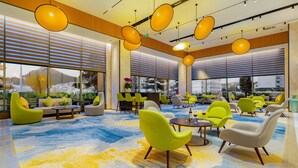 A spacious lobby with modern seating, large windows, and a vibrant carpet. - Holiday Inn One Thousand Island Lake by IHG (Hangzhou)
