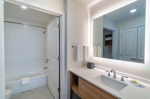 Un baño con bañera, lavabo y espejo.