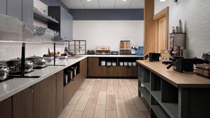 A modern kitchen with stainless steel appliances, wooden cabinets, and a white tiled backsplash. - Staybridge Suites Flowood Nw Jackson by IHG (Flowood)