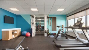 A gym with treadmills, exercise balls, and a weight rack. - avid hotel Byron Warner Robins by IHG (Byron)