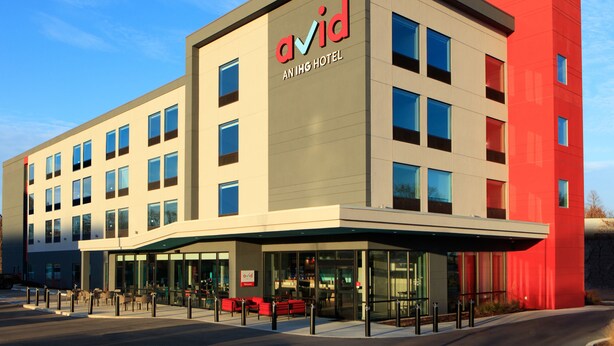 A modern hotel building with a prominent 'ovid' sign, multiple windows, and a covered entrance area. - avid hotel Byron Warner Robins by IHG (Byron)