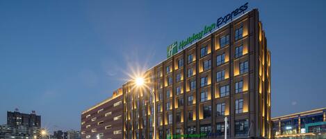 A Holiday Inn Express hotel with a modern facade, multiple floors, and illuminated signage.