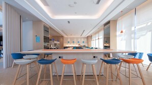 Una cocina moderna con una isla central, taburetes de bar e iluminación colgante.