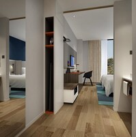 Una habitación de hotel moderna con cama, escritorio y zona de estar.