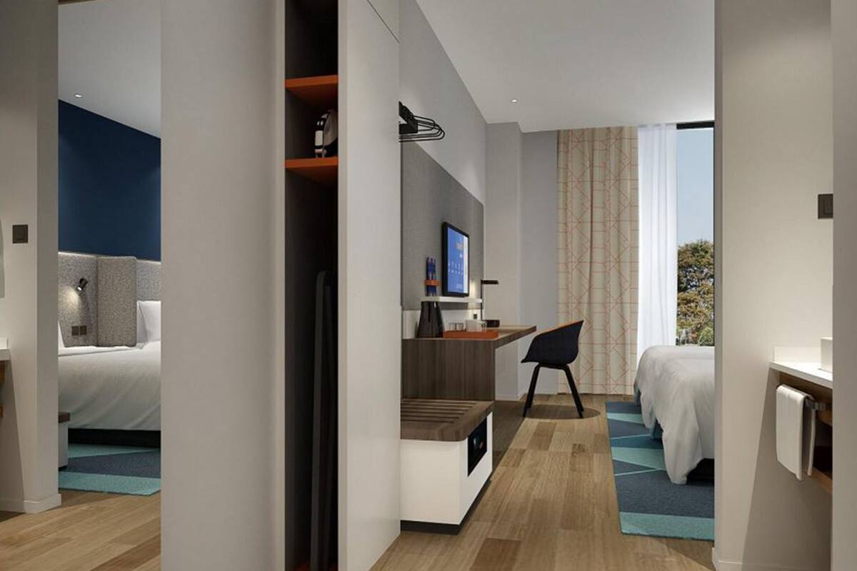 Ein modernes Hotelzimmer mit Bett, Schreibtisch und Sitzecke.
