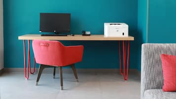 Un espacio de trabajo con un escritorio, una computadora, una impresora y dos sillas.