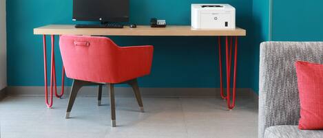 A workspace with a desk, a computer, a printer, and two chairs.