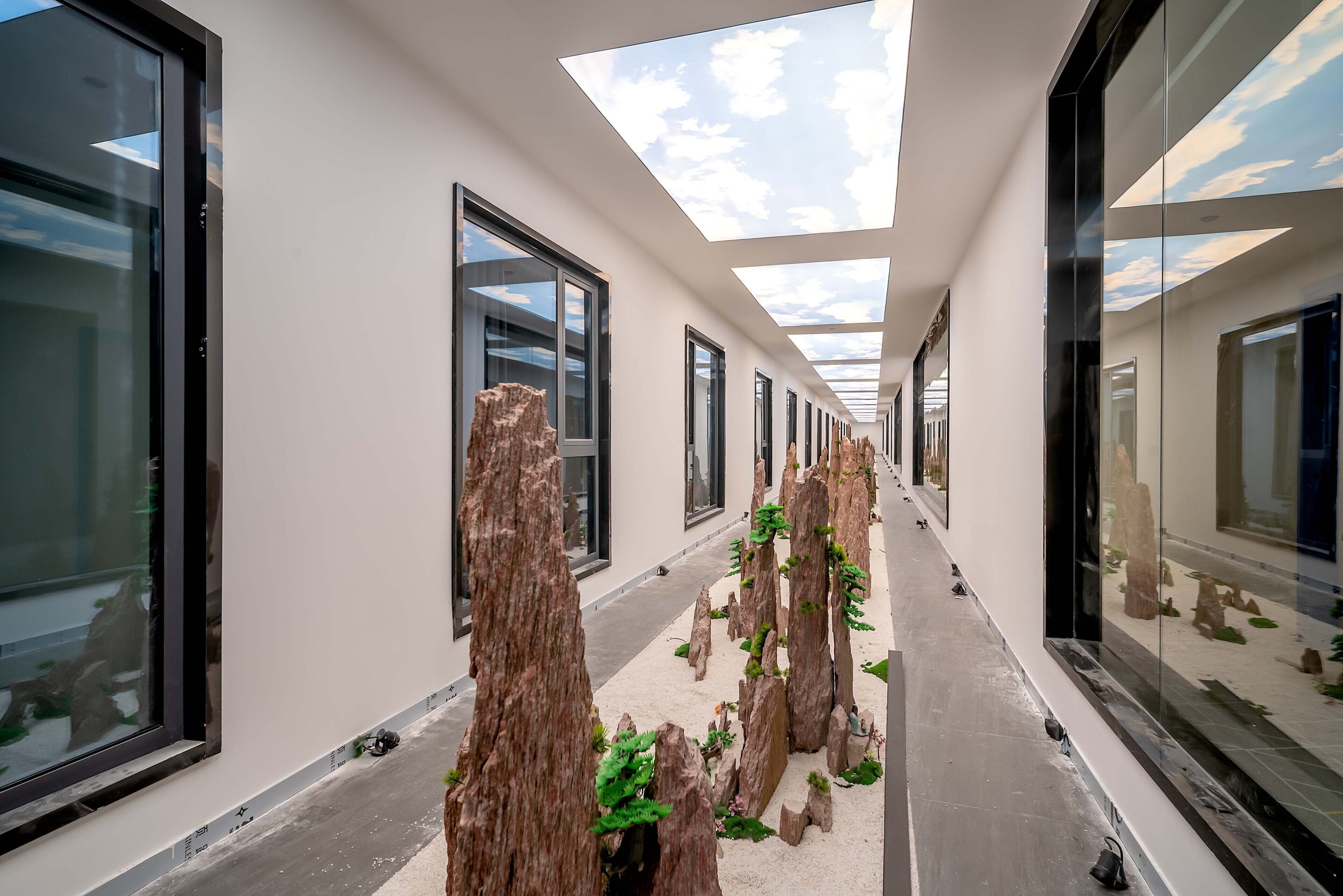 Un pasillo con paredes de vidrio, tragaluces y estructuras de madera que evocan árboles.