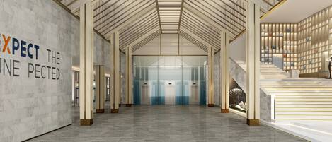 Un hall d’entrée spacieux avec un plafond haut, un sol en marbre et un escalier au design moderne.