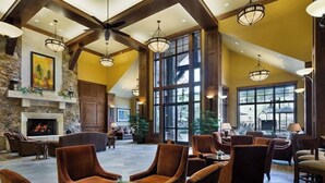 A spacious lobby with a fireplace, comfortable seating, and large windows. - Ski in Ski Out Luxury Resort  (Breckenridge)