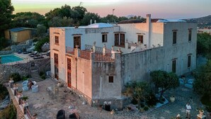 Un edificio con piscina, area salotto esterna e vista sul mare.