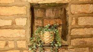 Un muro de ladrillo con una pequeña ventana.