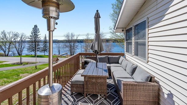A deck with outdoor furniture, a patio heater, and a view of a lake. - South Shore Lake House Haven (Edinburg)