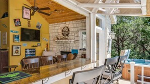 A bar area with a stone wall, wooden ceiling, and various framed pictures.