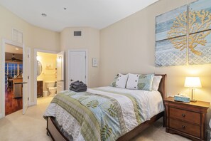 A bedroom with a bed, nightstand, and wall art.