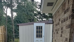 A small, single-story building with a white exterior and a door with a window.