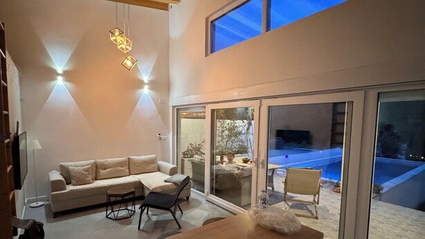 A modern interior with a wooden ceiling, a sofa, a dining table, and a view of a swimming pool through large glass doors. - House on the river, private pool, garden and barbecue . 2hours to Dubrovnik! (Malo Polje)