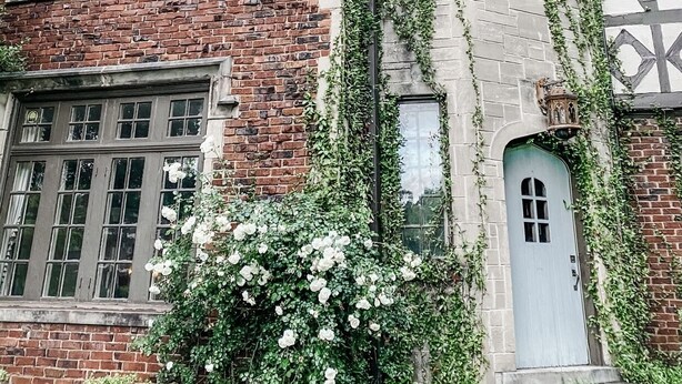 A two-story building with a brick facade and a corner turret. There are multiple windows, some with shutters, and a door with a small porch. - Spacious Historic Midtown Memphis Chateau Minutes from Everything  (Memphis)