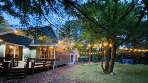 Een huis met een terras, een overdekte veranda en lichtjes.