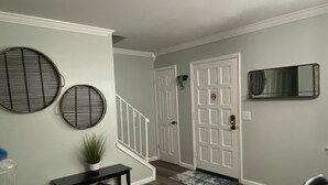 A hallway with a staircase, a dining area with a table and chairs, and a door with a no smoking sign. - Newly Renovated Cozy/Modern Pet-Friendly Villa for the entire family to enjoy. (Hilton Head Island)