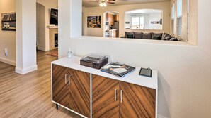 A modern living room with a white console table, wooden cabinets, and a ceiling fan. - 12 Mi to Riverwalk District: Quiet Reno Retreat (Reno)