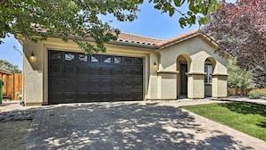 A house with a large garage, a brick driveway, and a well-maintained lawn. - 12 Mi to Riverwalk District: Quiet Reno Retreat (Reno)
