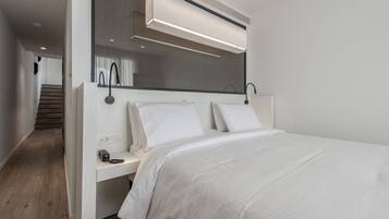 Camera da letto moderna con un letto grande, un comodino con una lampada e un condizionatore integrato sopra il letto.