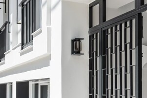 Un edificio bianco con infissi neri e un cancello in metallo.