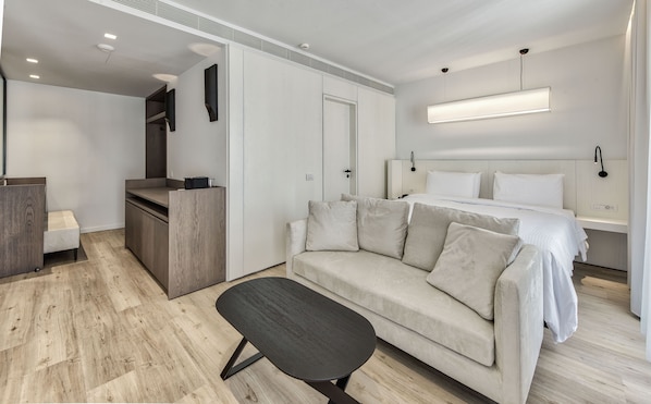 Un dormitorio moderno con cama, sofá, escritorio y banca.