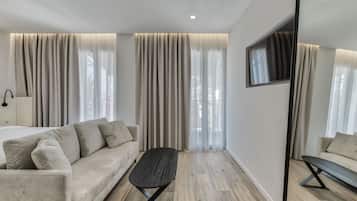 Une chambre d’hôtel moderne avec un canapé, une petite table et un téléviseur.