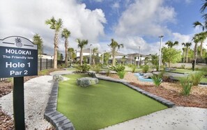 A miniature golf course with a sign reading "MOLOKAI The Friendly Isle Hole 1 Par 2".