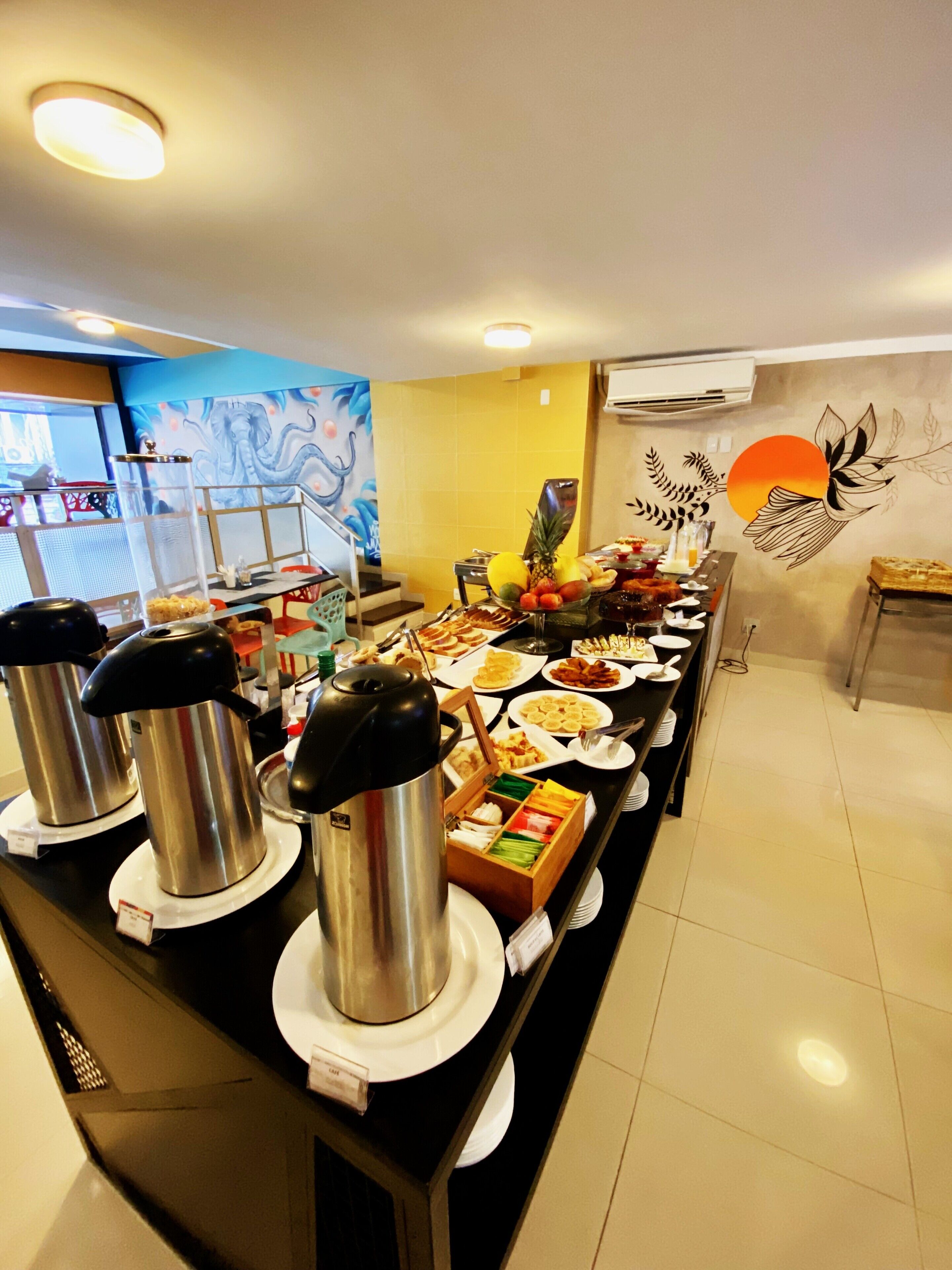 Una barra de buffet con diversos alimentos y una estación de café.