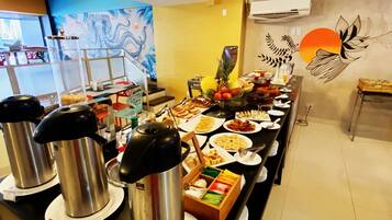 Una barra de buffet con diversos alimentos y una estación de café.