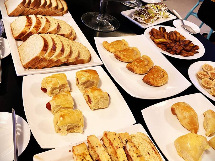 A buffet with various food items including bread, pastries, and fruits.