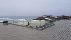 A modern deck with a glass railing overlooking the ocean. - Modern Ocean View  Condo with Private  Beach   (PLAYAS encantada, playa de Rosarito)