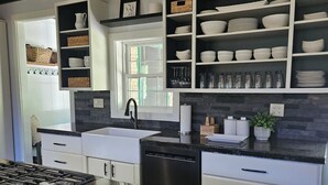 A modern kitchen with granite countertops, white cabinetry, and a built-in wine rack. - Name: Hill Side<br>Country Setting. Heated Pool.  4 minutes to Dreams Park. (Cooperstown)