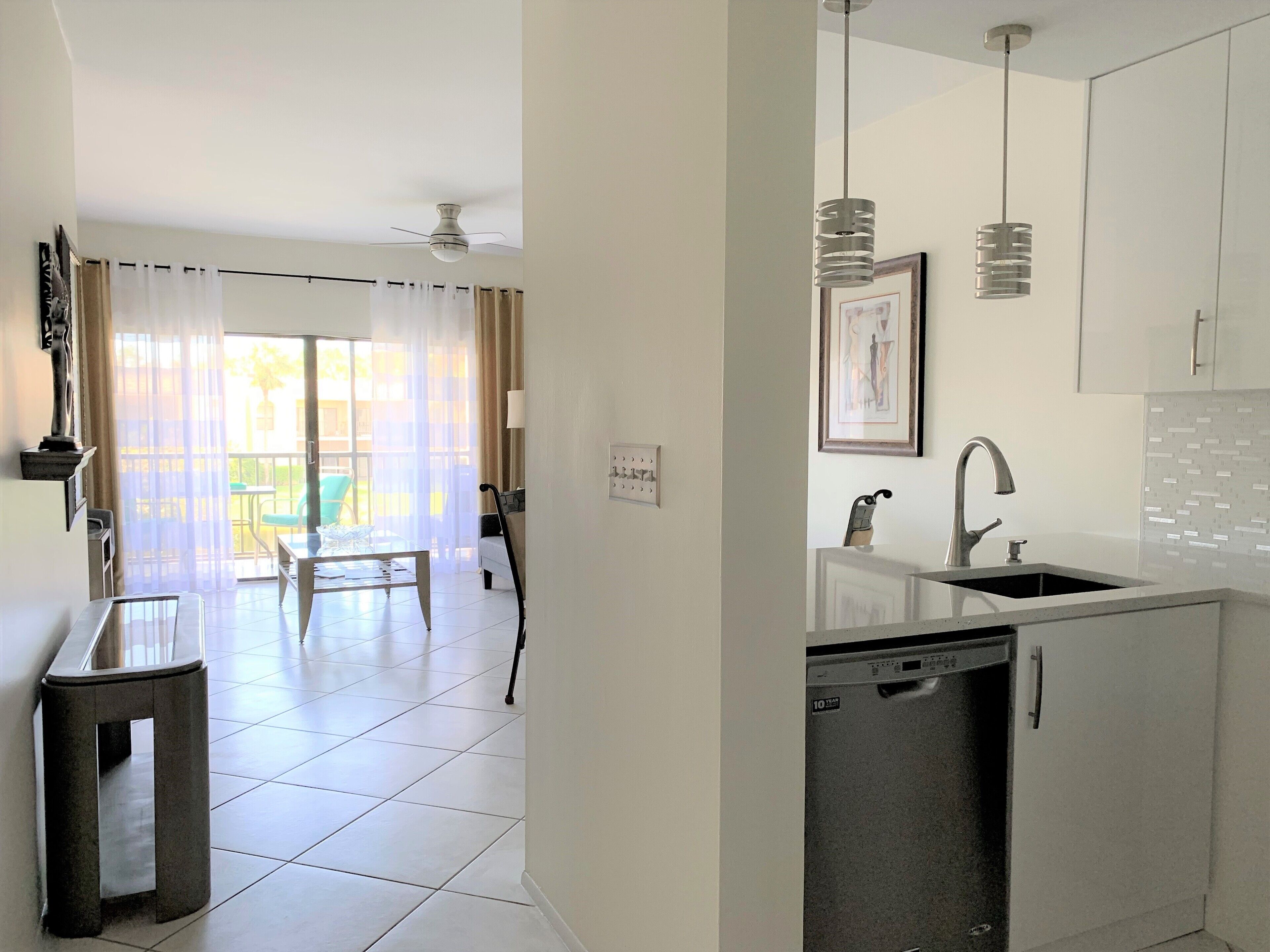Uma cozinha moderna com máquina de lavar louça, pia e área de jantar com mesa e cadeiras.