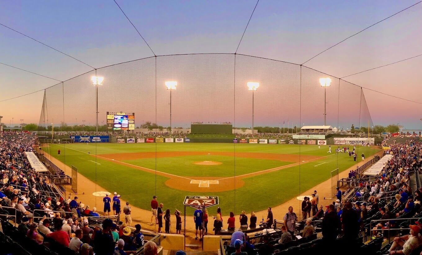Uno stadio di baseball con un'ampia zona di posti a sedere, un campo centrale e un tabellone segnapunti.