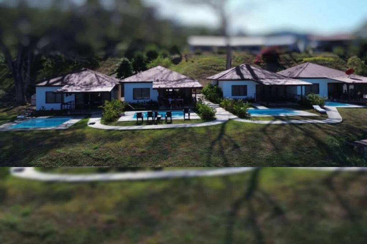A resort with multiple bungalow-style buildings, each with a pool.