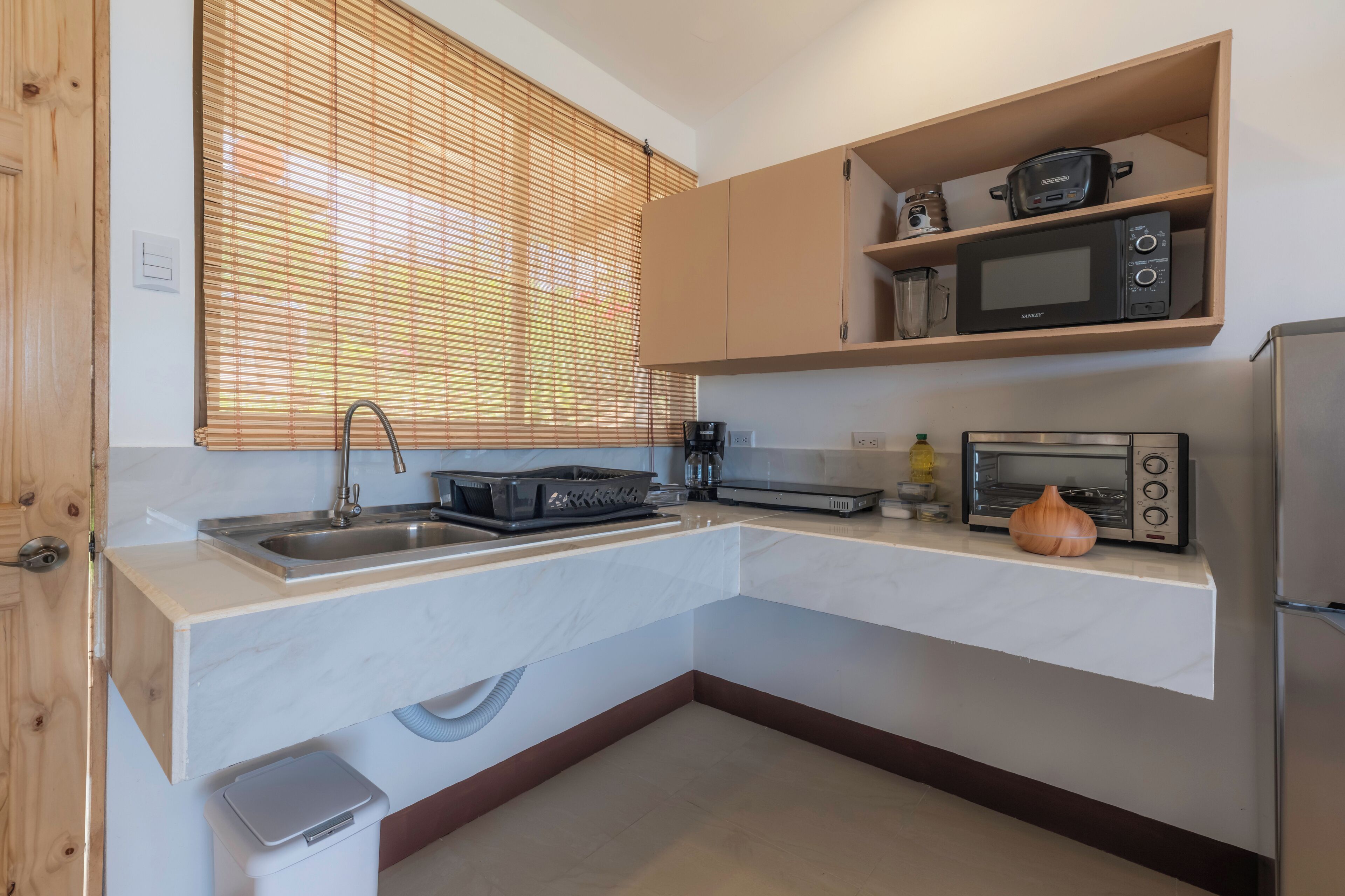 A compact kitchen with a built-in microwave, toaster, and a small oven.