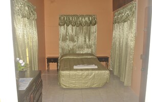 A room with a bed, two nightstands, a dresser, and curtains. - Superb Villa in Montego Bay (Montego Bay)
