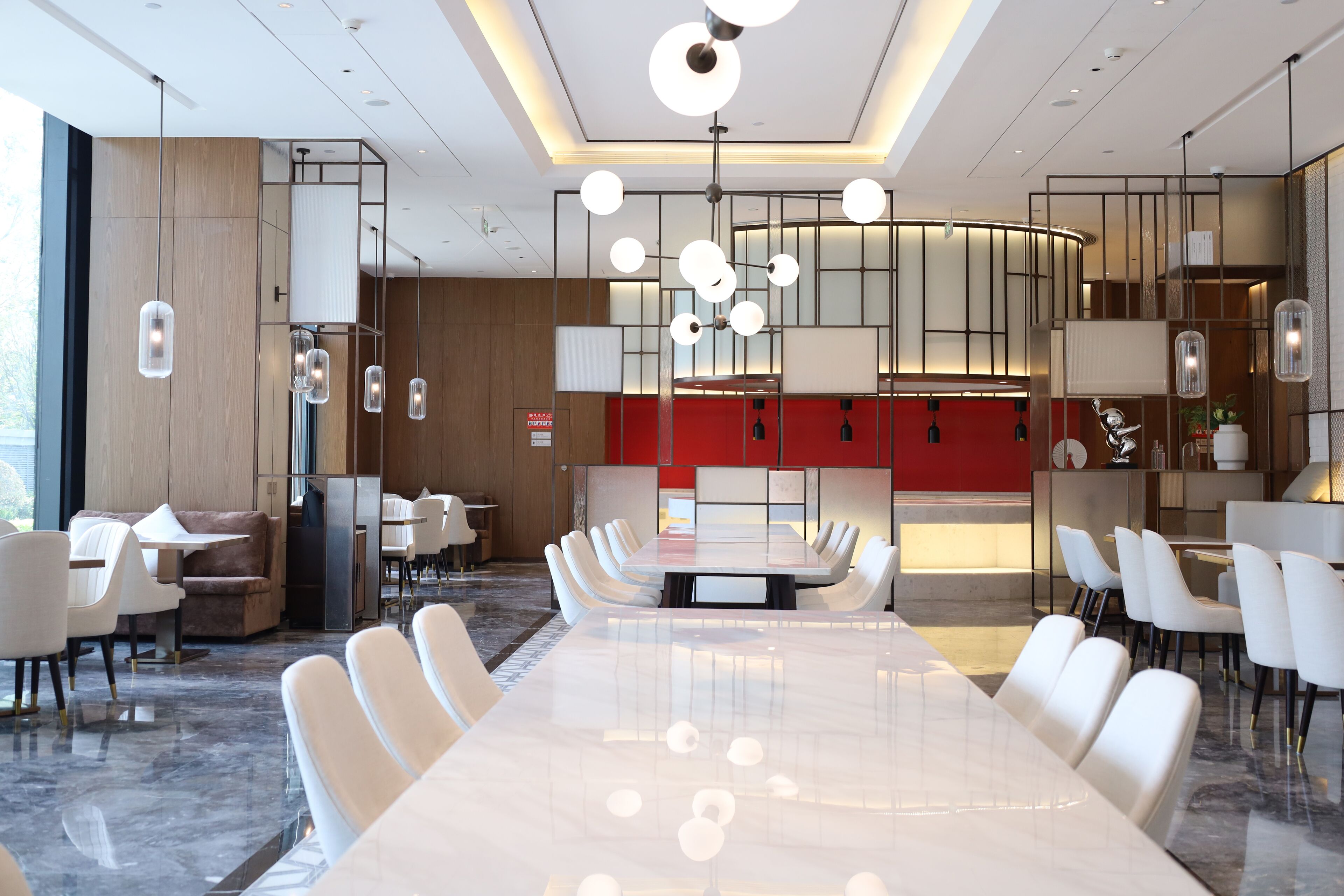 A modern conference room with a long table, white chairs, and pendant lighting.