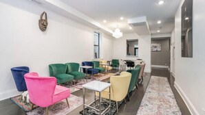 A modern living room with green and pink chairs, a coffee table, and a rug. -  LakeHouse with rooftop and views of lake. (Chicago)