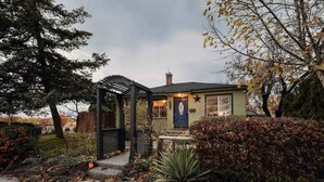 Una casa con porche cubierto, una puerta azul y un adorno con forma de estrella.
