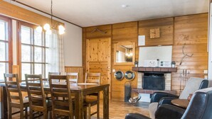A cozy dining area with wooden chairs and a table, a fireplace, and a seating area with a leather couch. - Saariseläntie 8 d7 by Interhome (Inari)