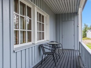 Relax on the covered porch with a grassy view and comfortable seating for two.