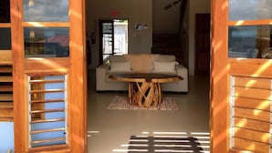 A wooden-framed room with a sofa and a round table with a tree stump base.